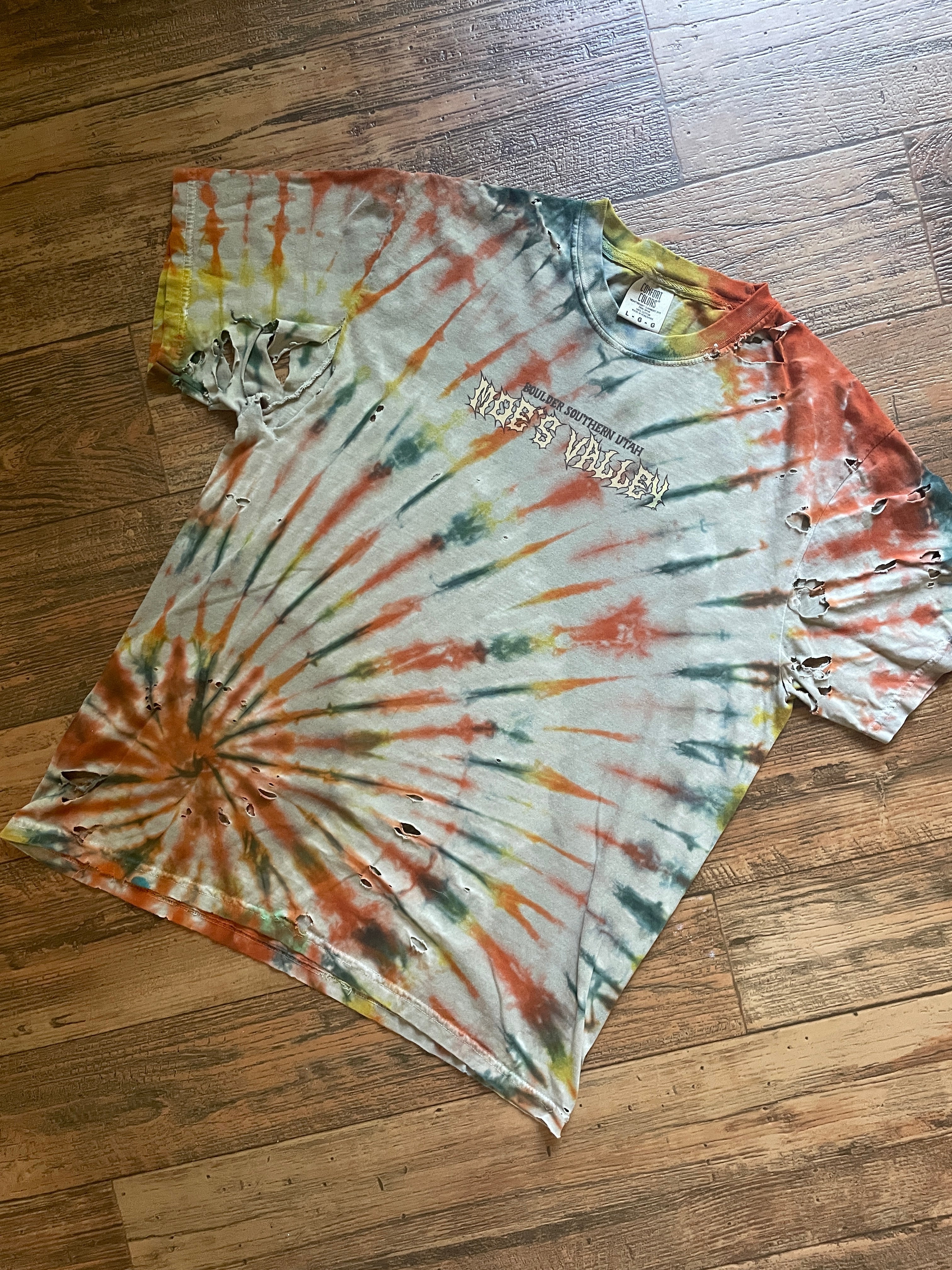 Tie-dye t-shirt with a logo on a wooden floor
