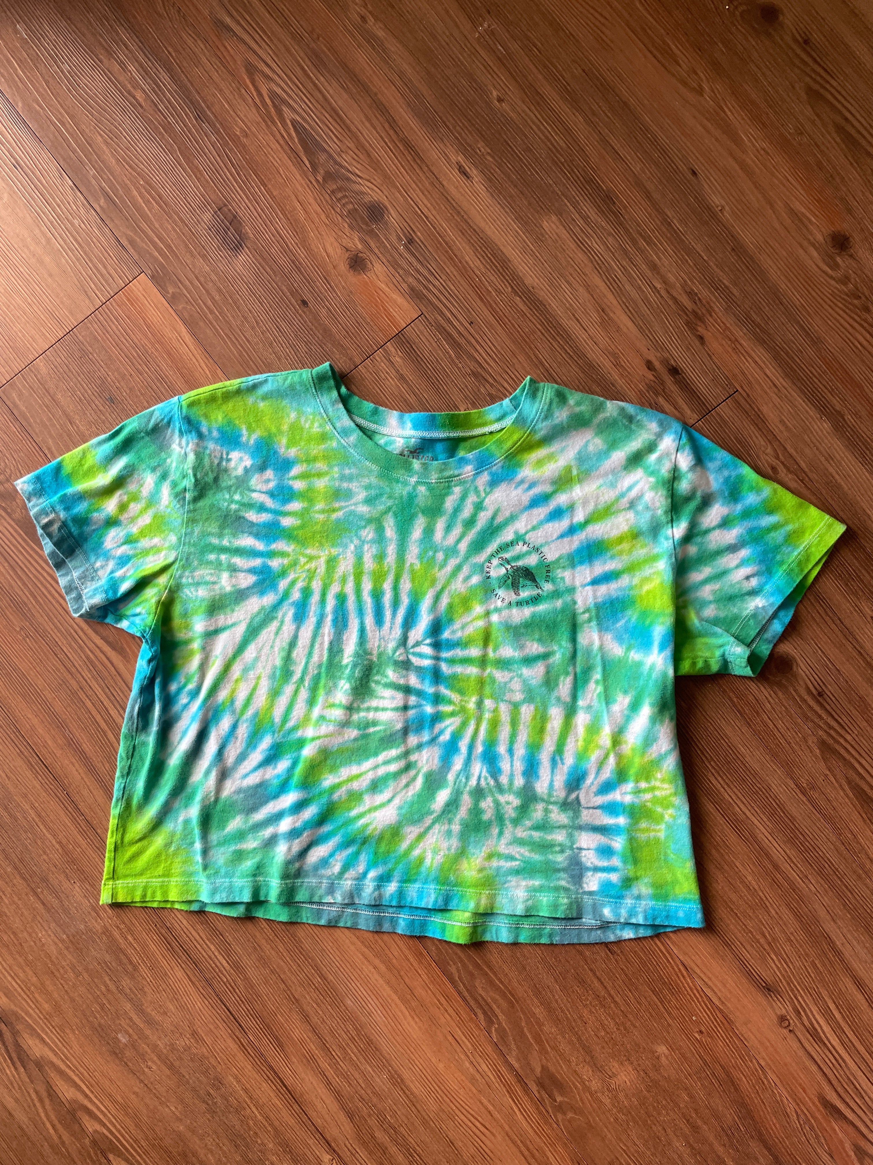LARGE Women’s/SMALL Men's Keep the Sea Plastic Free Tie Dye Crop Top | Shades of Green and Blue Pleated Tie Dye Short Sleeve Top