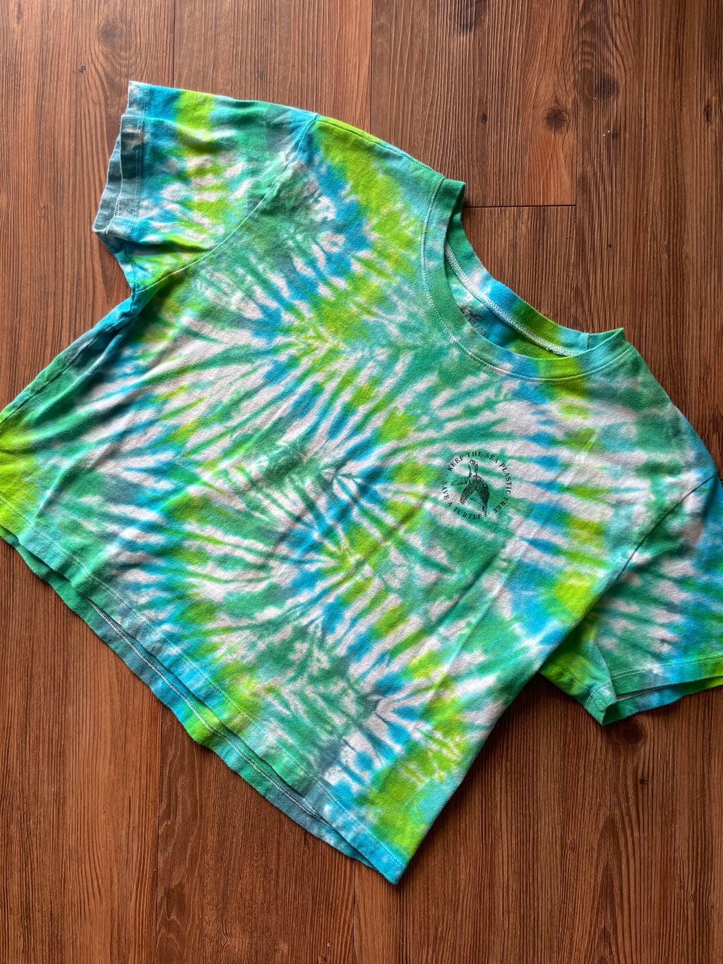 LARGE Women’s/SMALL Men's Keep the Sea Plastic Free Tie Dye Crop Top | Shades of Green and Blue Pleated Tie Dye Short Sleeve Top
