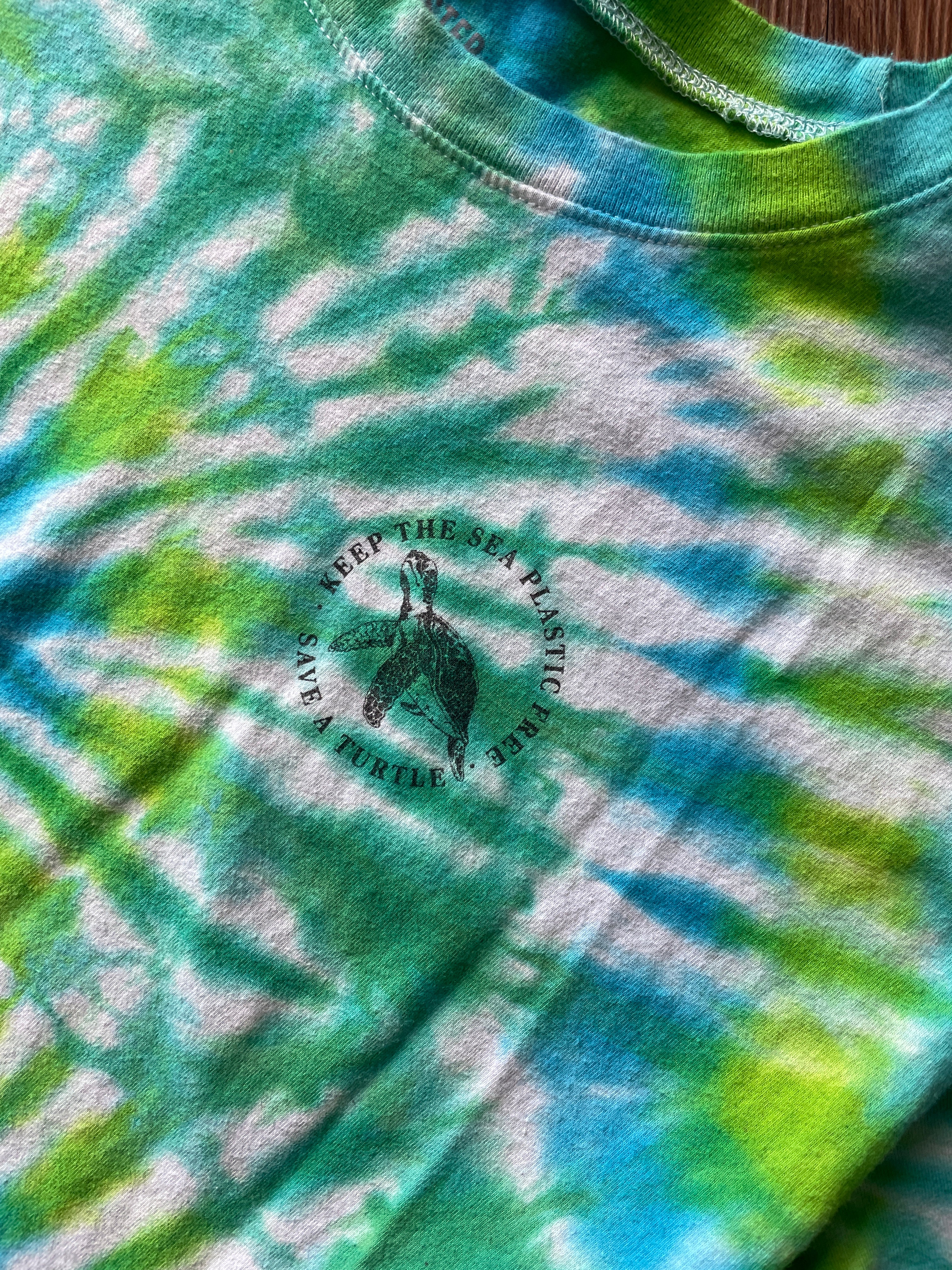 LARGE Women’s/SMALL Men's Keep the Sea Plastic Free Tie Dye Crop Top | Shades of Green and Blue Pleated Tie Dye Short Sleeve Top